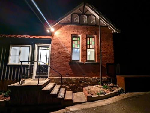 ein Backsteinhaus mit einer Treppe davor in der Nacht in der Unterkunft Elements Of Goulburn in Goulburn