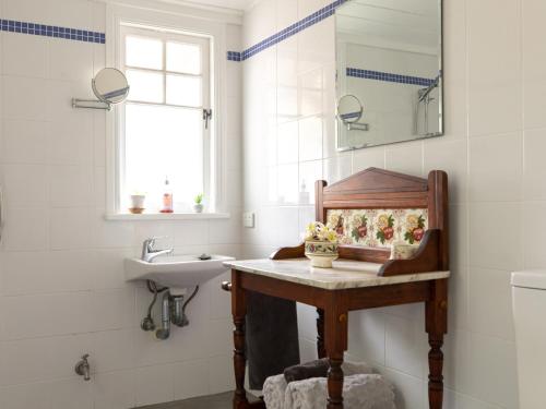 La salle de bains est pourvue d'un lavabo et d'un miroir. dans l'établissement Chesson Lodge, à Uki