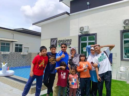 a group of people standing in front of a house at SARASERA HOMESTAY with PRIVATE POOL MELAKA in Melaka
