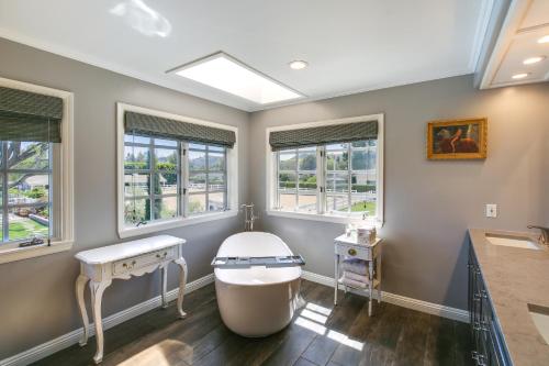 a bathroom with a tub and a sink and windows at Stunning Home in Orange County with Stables! in Orange