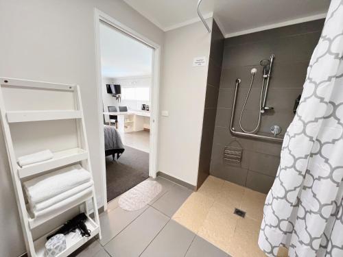 a bathroom with a walk in shower and a mirror at Continental Motel in Whangarei