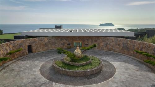 un jardín frente a un edificio con una fuente en JW Marriott Jeju Resort & Spa en Seogwipo