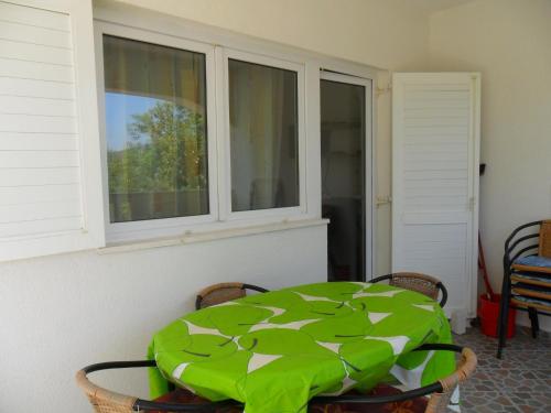 una mesa verde en una habitación con ventana en Apartments Gor en Sevid