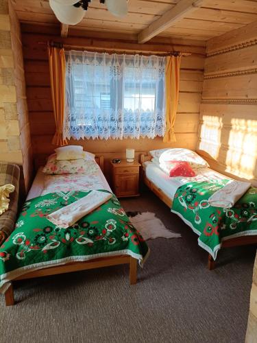 um quarto com 2 camas num chalé de madeira em Pokoje Gościnne Grażyna Kozioł em Zakopane