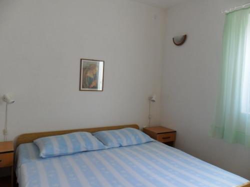 1 dormitorio con cama con sábanas azules y ventana en Apartments Gor en Sevid