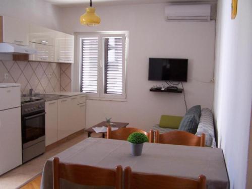 cocina y sala de estar con mesa y sofá en Apartments Maja - free parking, en Novalja