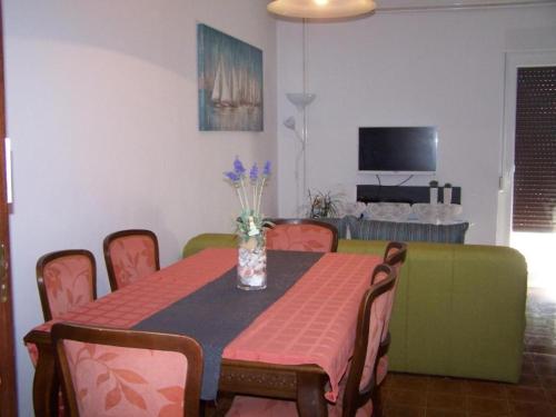 una mesa de comedor con un jarrón de flores. en Apartments Maja - free parking, en Novalja