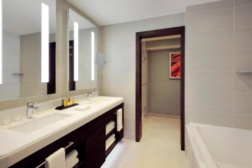 La salle de bains est pourvue de 2 lavabos et d'un grand miroir. dans l'établissement SAAD Hotel Astana, à Astana