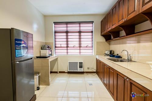 a kitchen with a stainless steel refrigerator and a window at Verjandel Residences in Manila