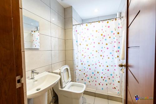 a bathroom with a toilet and a sink and a shower at Verjandel Residences in Manila
