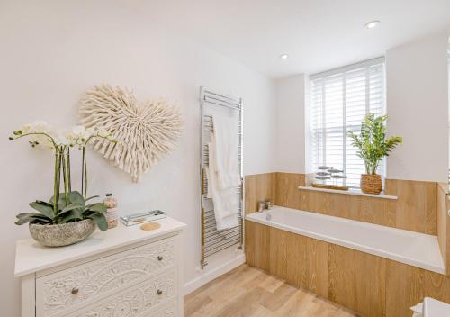 a bathroom with a bath tub and a window at Argraig in Abersoch