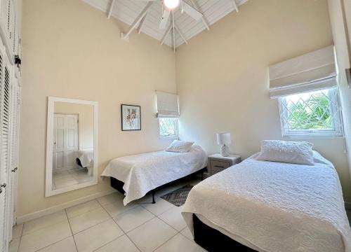 - une chambre avec 2 lits et un miroir dans l'établissement 12 Foursquare Rockley Golf & Country Club, à Bridgetown