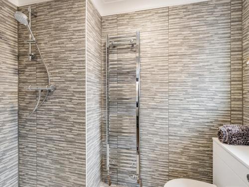 a bathroom with a shower with a glass door at The Beach Bungalow in Beltinge