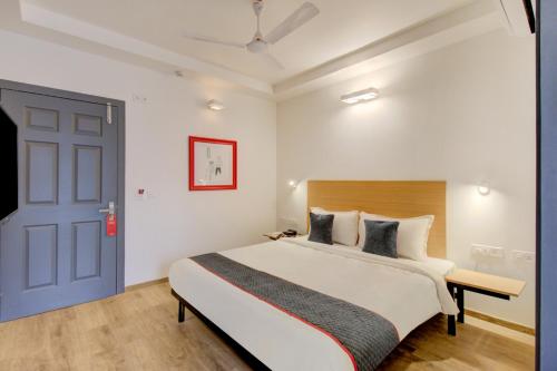 um quarto com uma cama grande e uma porta azul em Hotel Q Rooms BTM Layout Near Gopalan Innovation Mall em Bangalore