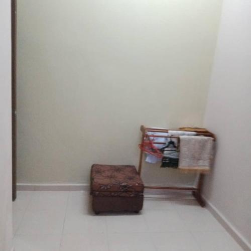 a room with a suitcase and a shelf with towels at Sobey Laris Homestay AZANA in Pasir Mas