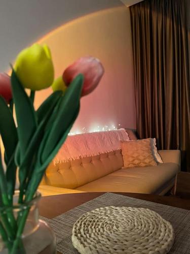 a living room with a couch and a vase with flowers at Cosy Ins Genting view 2 Bedrooms Home at Geo38 Premier Suites with 100mpbs WiFi available in Genting Highlands