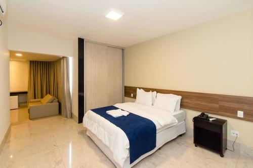 a bedroom with a large bed with a blue blanket at Nita Palace Hotel in Pompeu