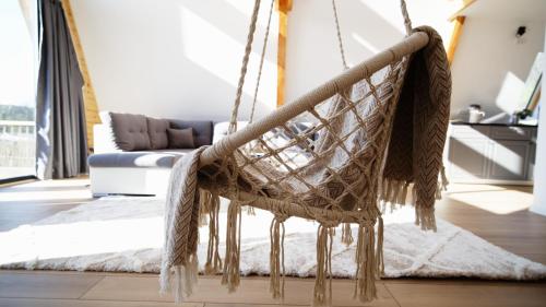 a hanging hammock in a living room with a couch at Cabanele A Frame, Salciua Noua 