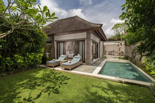 a backyard with a swimming pool and a villa at Visesa Ubud Resort in Ubud
