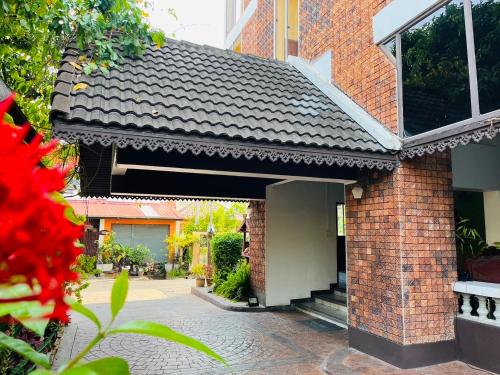 a brick building with a black roof and a brick sidewalk at Wiriya House in Chiang Mai