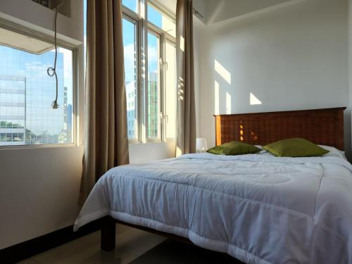 a bedroom with a bed with a large window at Casa Antonio at Stamford McKinley Hill Unli Wi-Fi Near Piazza in Manila
