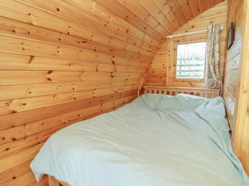 a bedroom in a log cabin with a bed in it at Elm 4 in Broadway