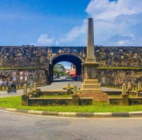 a monument in front of a wall with a tunnel at DiNi Galle in Galle