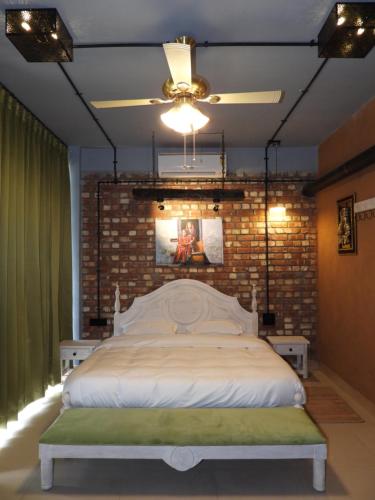 a bedroom with a large bed with a brick wall at Mystic Kailasha Kedarnath - Tungnath Valley in Sari