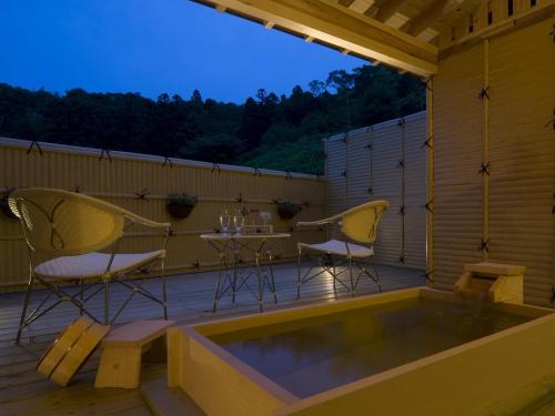 a patio with chairs and a table on a deck at Hotel Oyanagi in Tagami