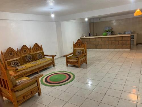 a living room with couches and chairs on a tile floor at Casa Mila in Taxco de Alarcón