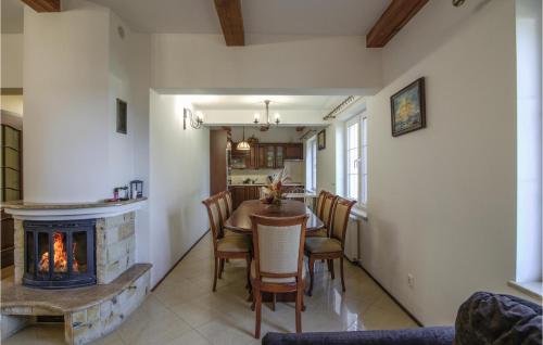a living room with a fireplace and a table and chairs at 3 Bedroom Lovely Home In Bogaczewo in Bogaczewo