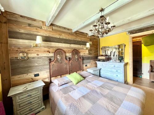 ein Schlafzimmer mit einem Bett und einer Holzwand in der Unterkunft Casa Unica- da Bruno in Colico