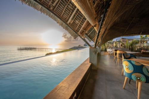 un complejo con piscina infinita con vistas al océano en Bamboo Zanzibar en Jambiani