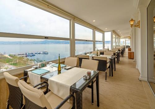 a row of tables in a restaurant with large windows at Wellborn Luxury Hotel in Kocaeli