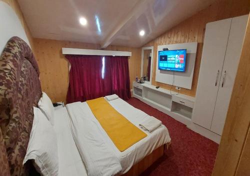 a hotel room with a bed and a tv at Hotel Outlook in Pahalgām