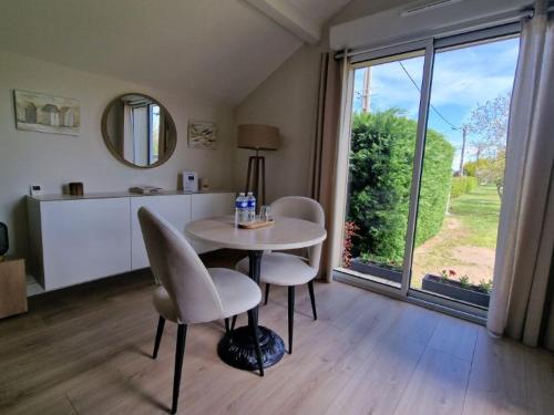 Habitación con mesa, sillas y ventana grande. en La Palentine, en Châteaumeillant