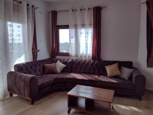 Ruhige, helle Wohnung beim Lac Rose في داكار: غرفة معيشة مع أريكة بنية وطاولة