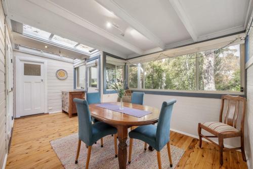 a dining room with a wooden table and chairs at Currawong in Blackheath