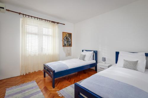1 dormitorio con 2 camas y ventana en Apartment Cesar, en Dobrota