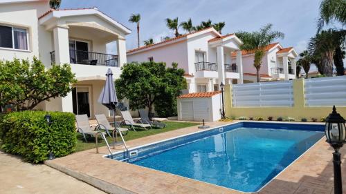 Villa con piscina frente a una casa en Villa Sofia en Coral Bay