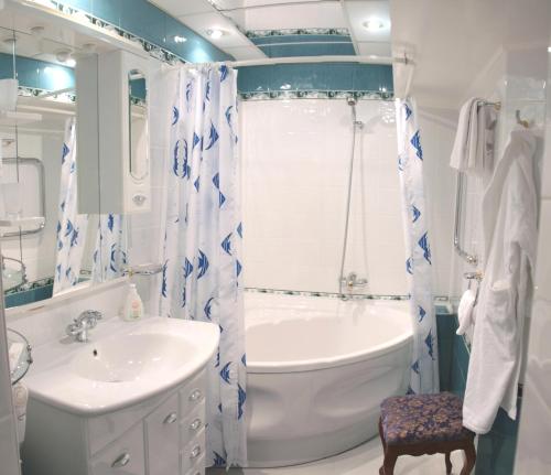 y baño con bañera, lavamanos y bañera. en Petropavlovsk Hotel en Petropávlovsk-Kamchatski