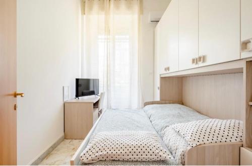 a small bedroom with a bed and a television at Mi casa tu casa - Guest House in Catania