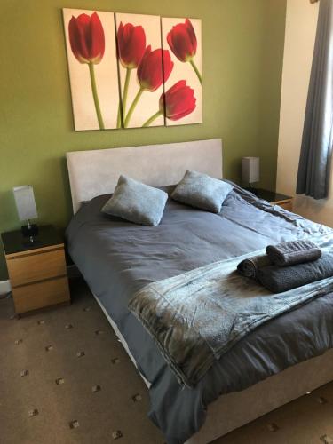 1 dormitorio con 1 cama con flores rojas en la pared en 2 Bedroom Bungalow, en Mawdesley