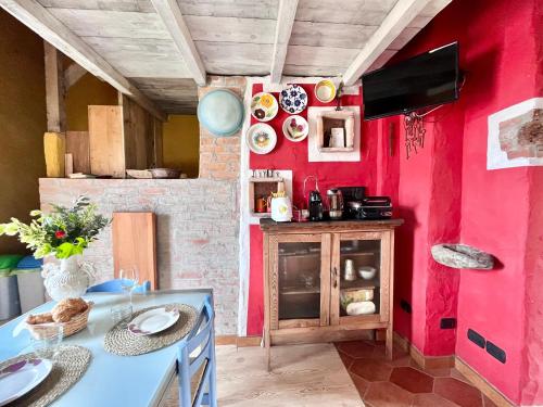 a kitchen with a table and a red wall at Casa Unica- da Bruno in Colico