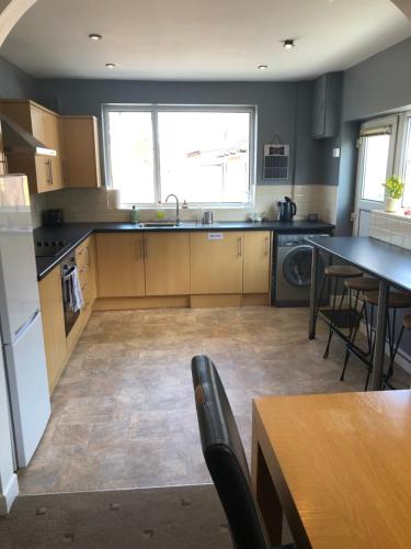 a kitchen with wooden cabinets and a table and chairs at 2 Bedroom Bungalow in Mawdesley