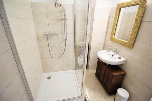 uma casa de banho com um chuveiro, um WC e um lavatório. em Rest House Apartman em Nyíregyháza