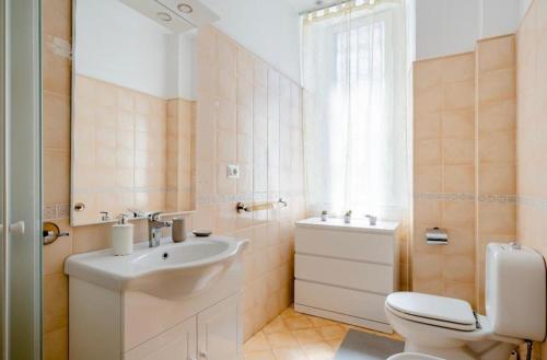 La salle de bains blanche est pourvue d'un lavabo et de toilettes. dans l'établissement Mi casa tu casa - Guest House, à Catane