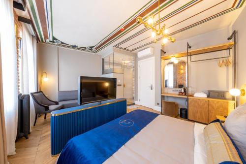 a bedroom with a large blue bed and a television at Hotel Balo in Istanbul