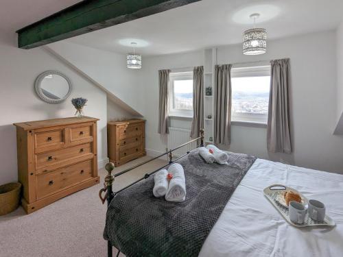 a bedroom with a bed with two pairs of shoes on it at White Cottage in Llandudno