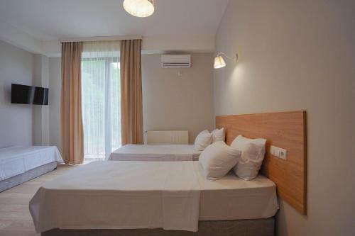 a hotel room with two beds and a window at Tilia Kvareli Resort in Kvareli